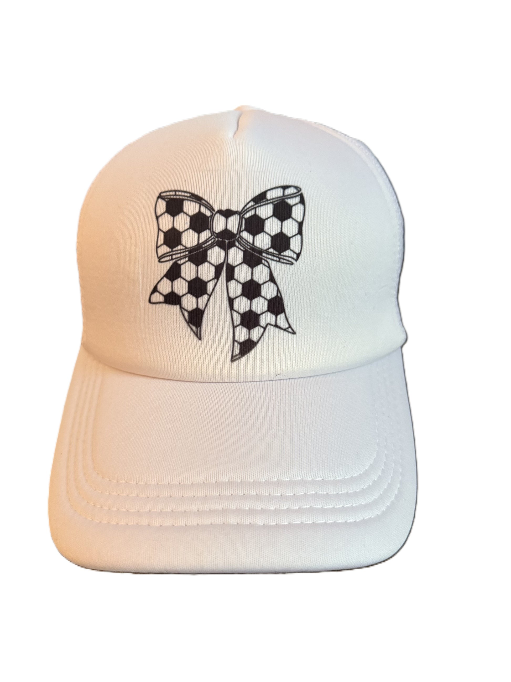 Front view of a white trucker-style cap featuring a black-and-white soccer ball patterned bow design on the front panel. Roxzell
