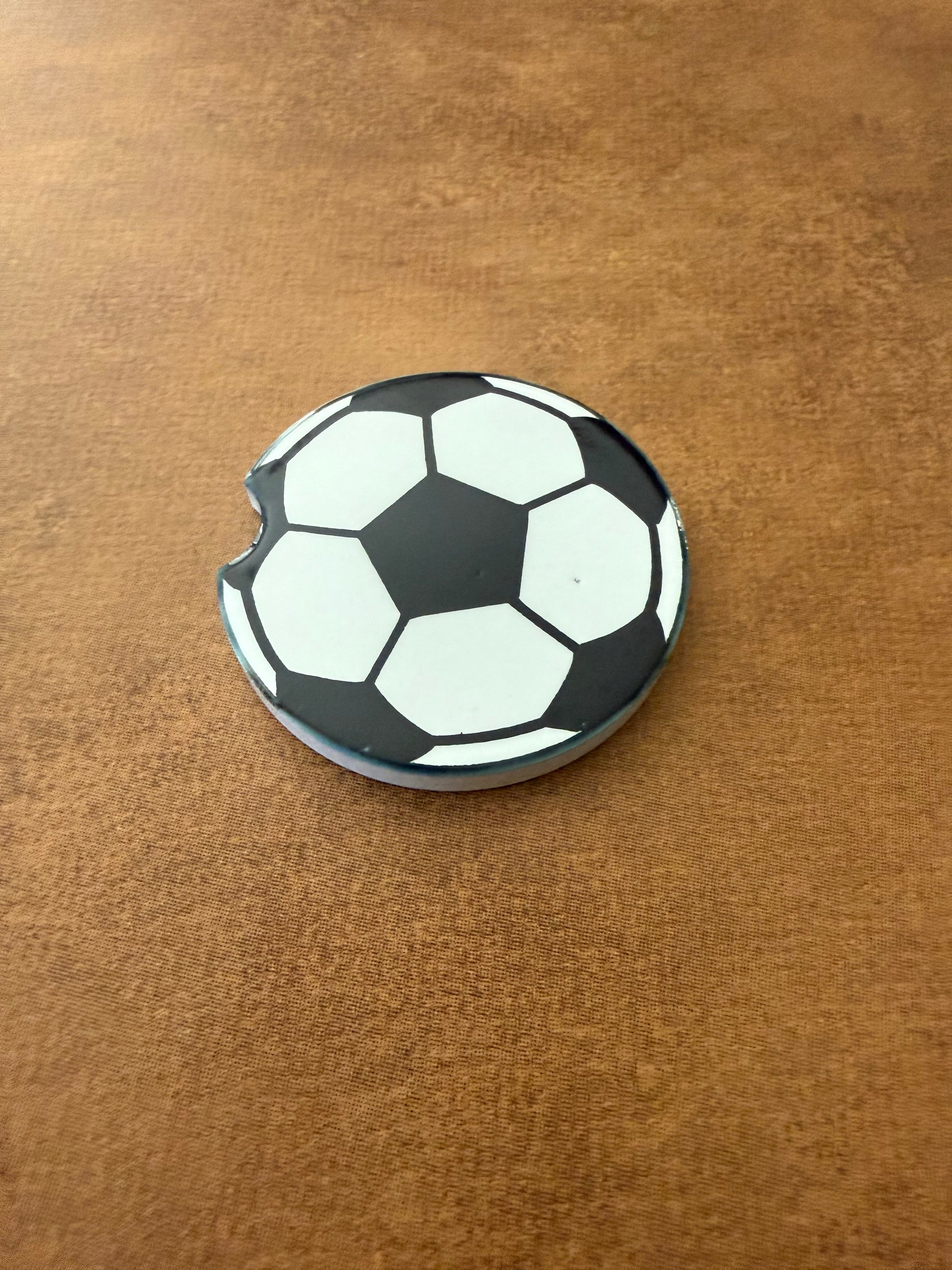 A ceramic car coaster with a soccer ball design Roxzell