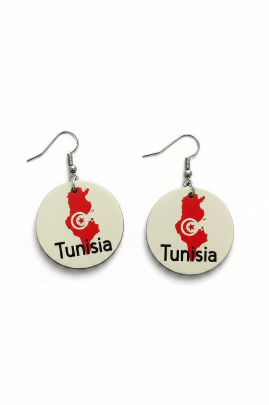 Pair of circular earrings featuring Tunisia’s map outline in red with a white crescent and star emblem and the word “Tunisia” printed below, displayed on a white surface. Roxzell