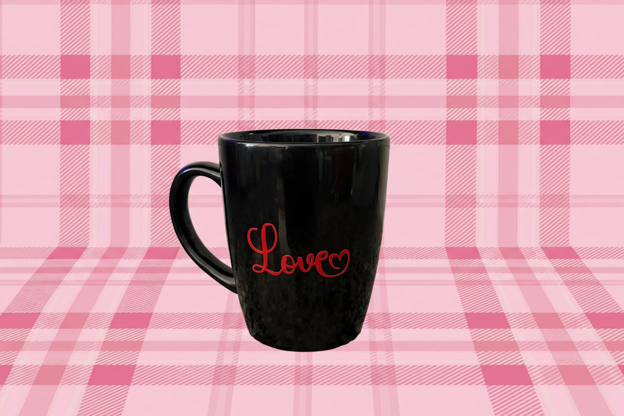 Black coffee mug with “Love” text and heart pattern on pink plaid background, Roxzell
