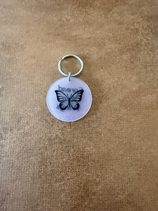  White acrylic butterfly keychain with "Spread Your Wings" on the reverse side.