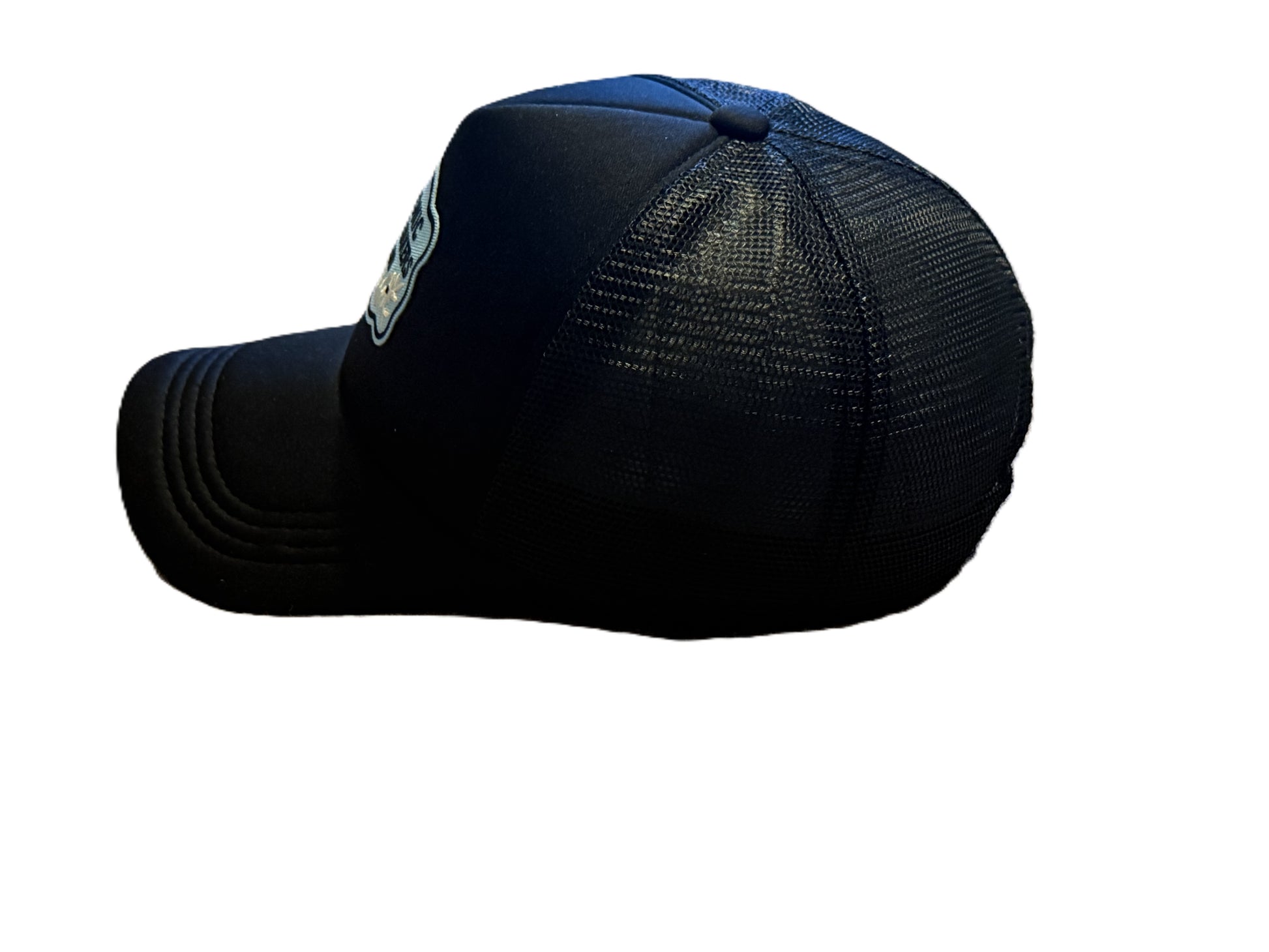 Left side view of black trucker hat with “Chronic Overthinkers Club” embroidered patch. Roxzell