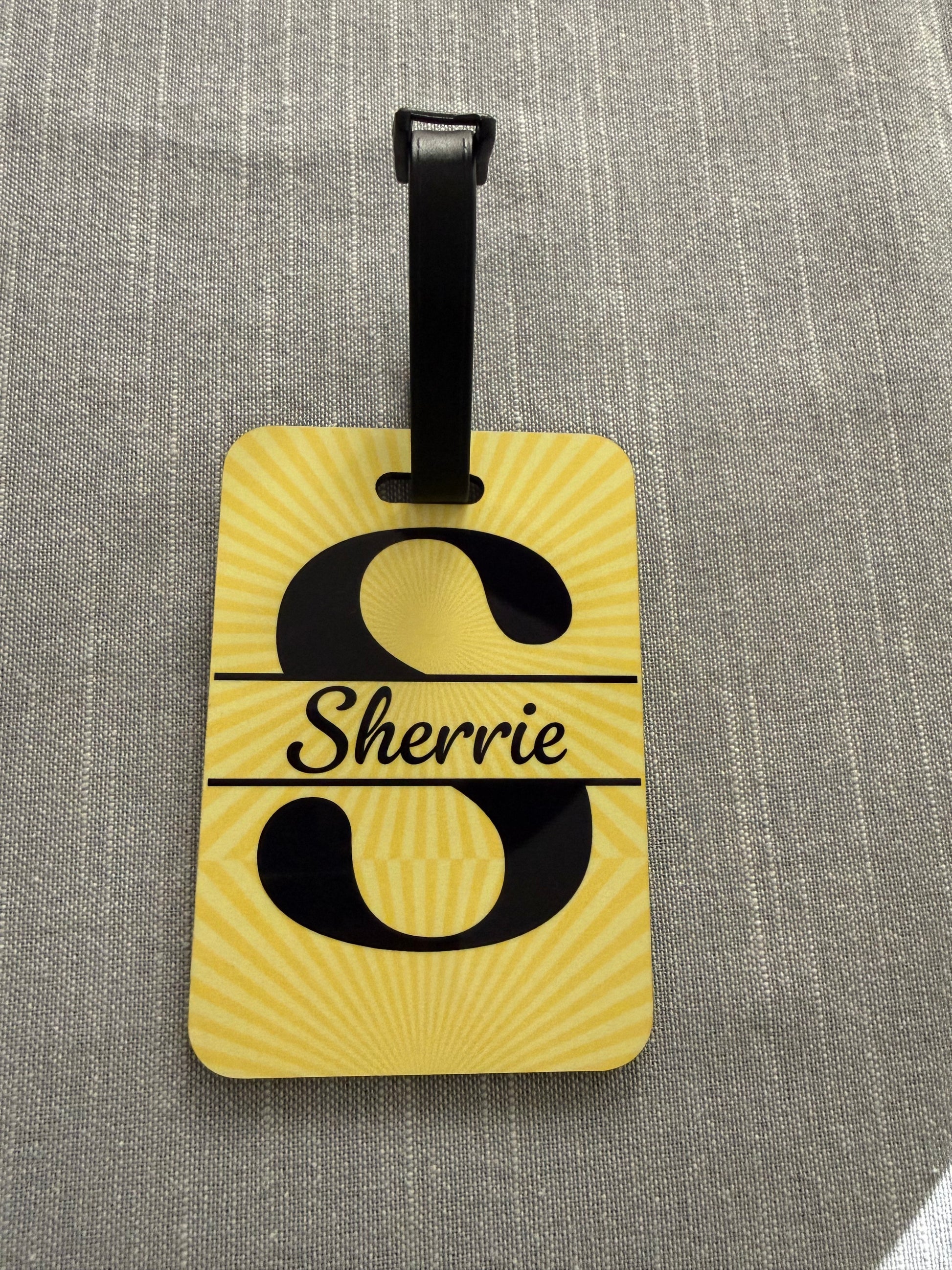 Luggage tag with a letter "S" design and "Sherrie" name on a textured gray background, Roxzell