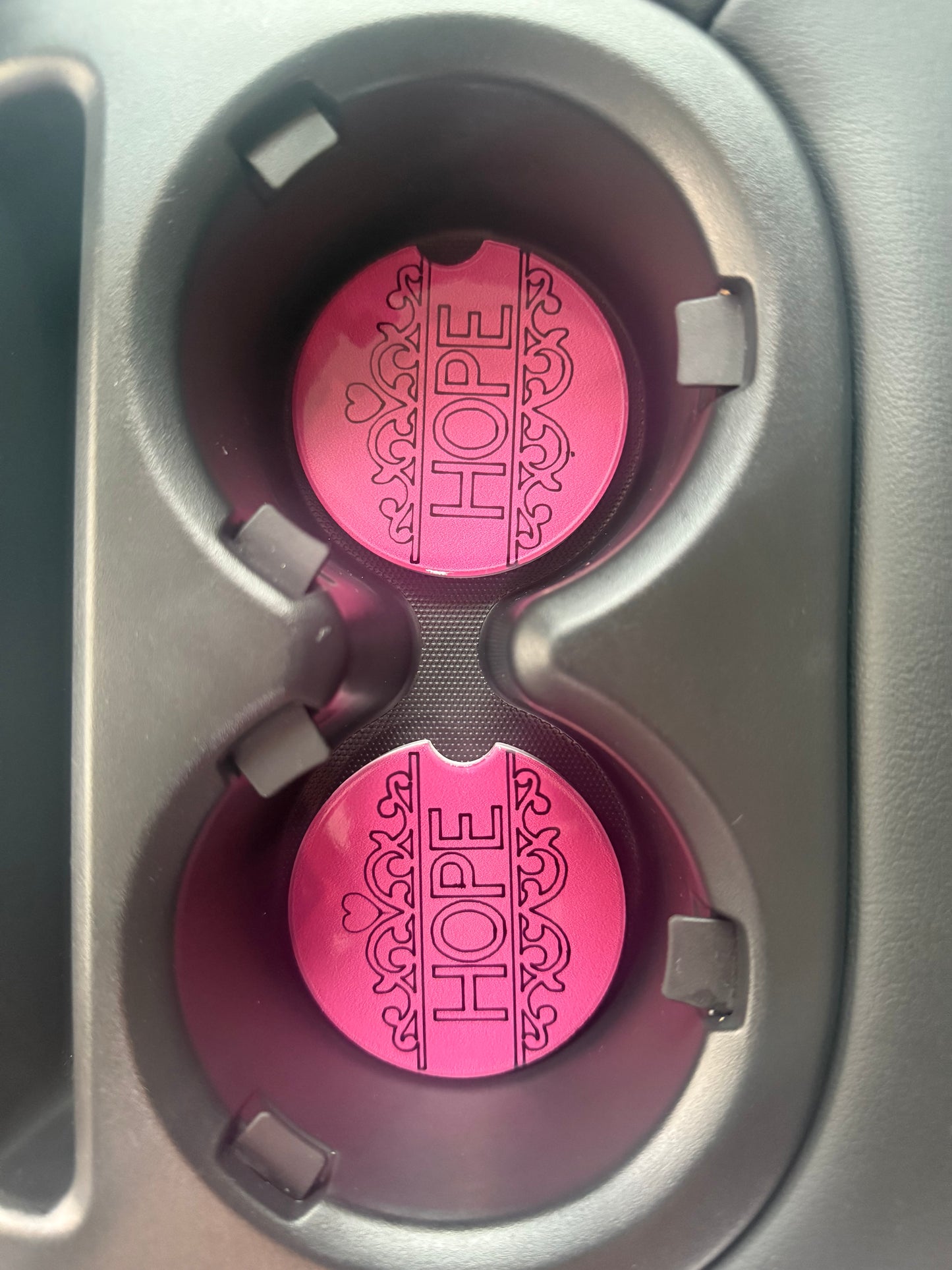 Two decorative pink and black car coaster with uplifting “HOPE” message in a car cupholder, Roxzell