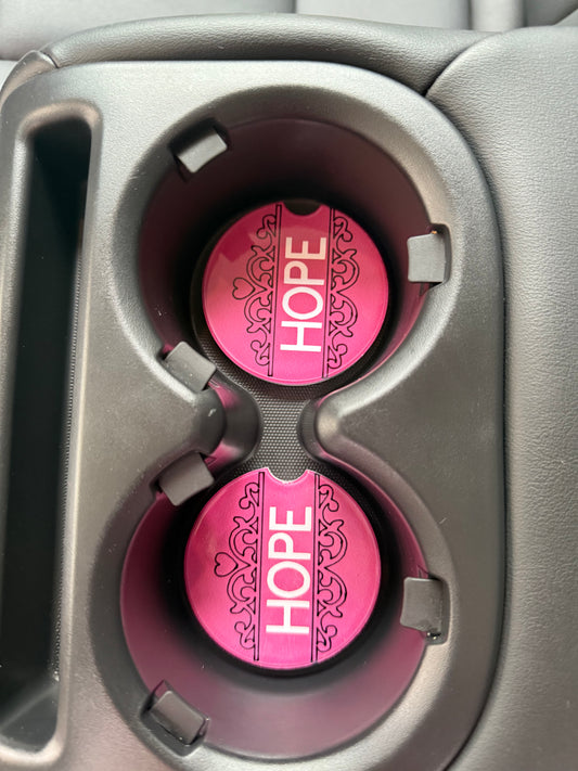 Two decorative pink and white car coaster with uplifting “HOPE” message in a car cupholder, Roxzell