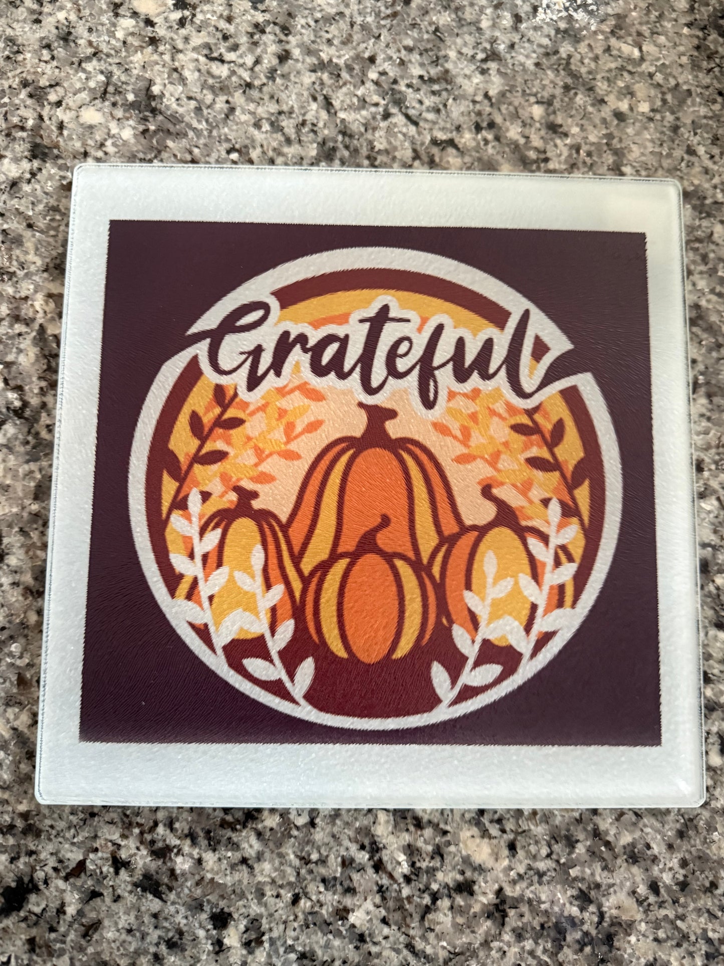 Decorative glass cutting board with pumpkins placed on granite surface, Roxzell