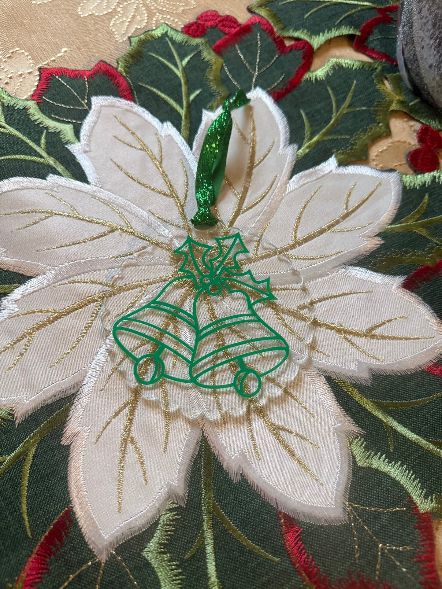 Christmas ornament with green outlined bells and holly, ideal for seasonal decorating or gifting.