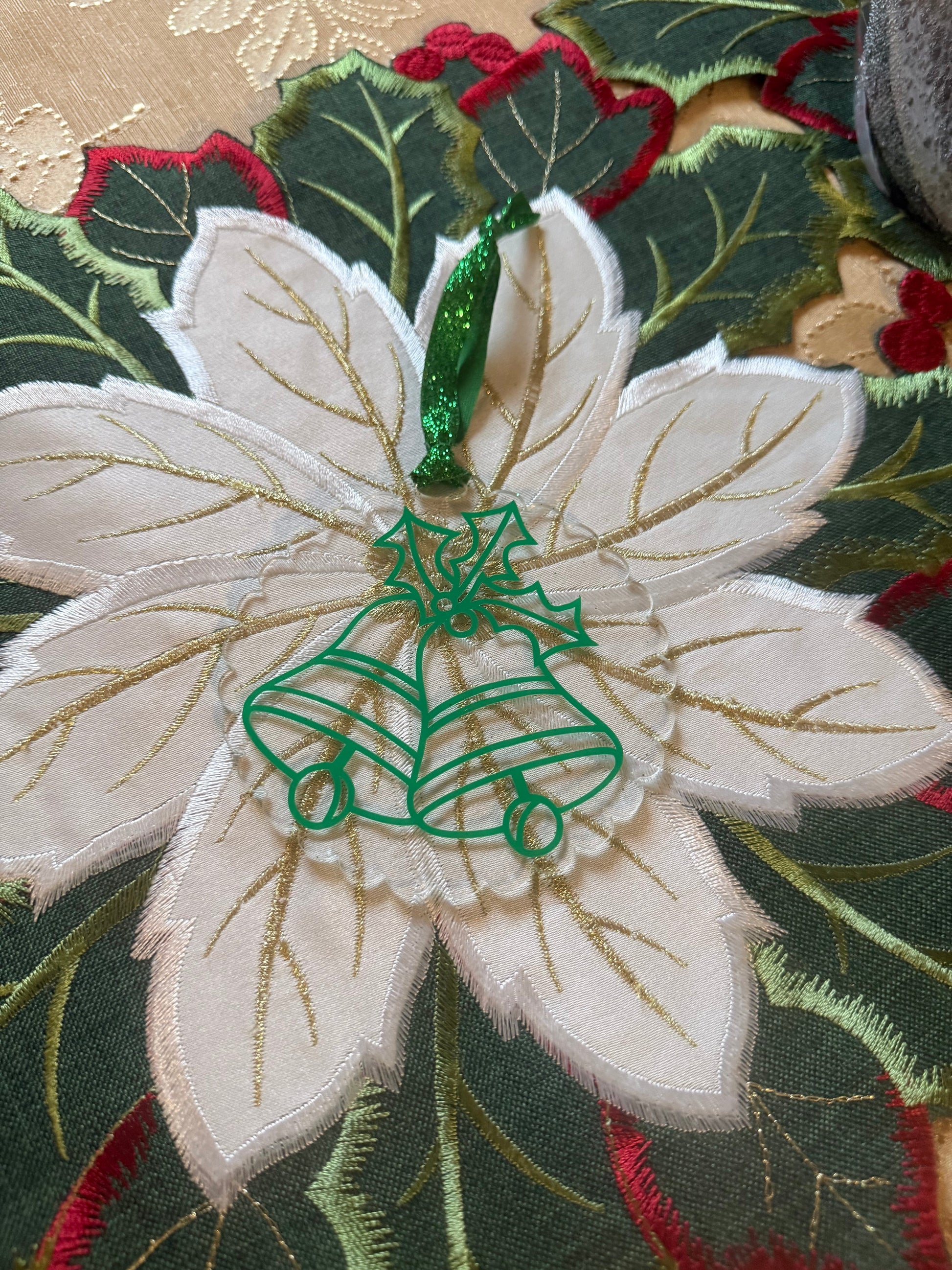 Christmas ornament with green outlined bells and holly, ideal for seasonal decorating or gifting.