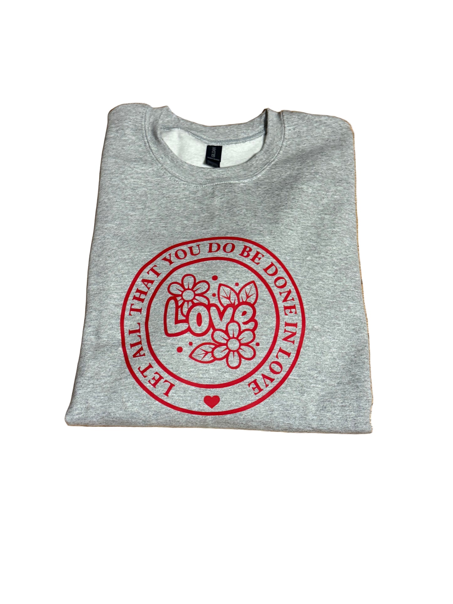 Gray sweatshirt with "Let All That You Do Be Done In Love" saying in a red circle.  The word "Love" and flowers in the center of the circle, Roxzell