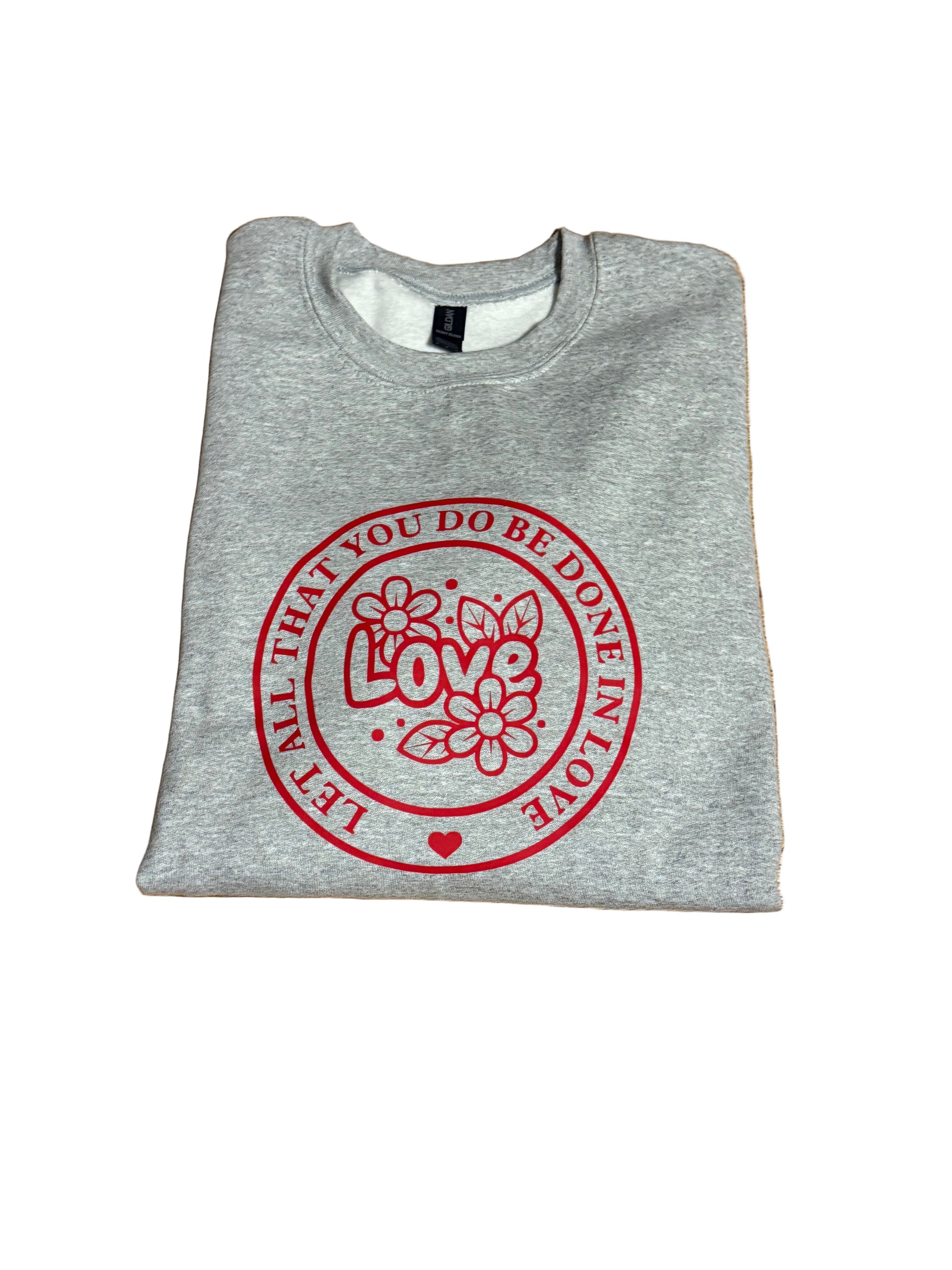 Gray sweatshirt with "Let All That You Do Be Done In Love" saying in a red circle.  The word "Love" and flowers in the center of the circle, Roxzell