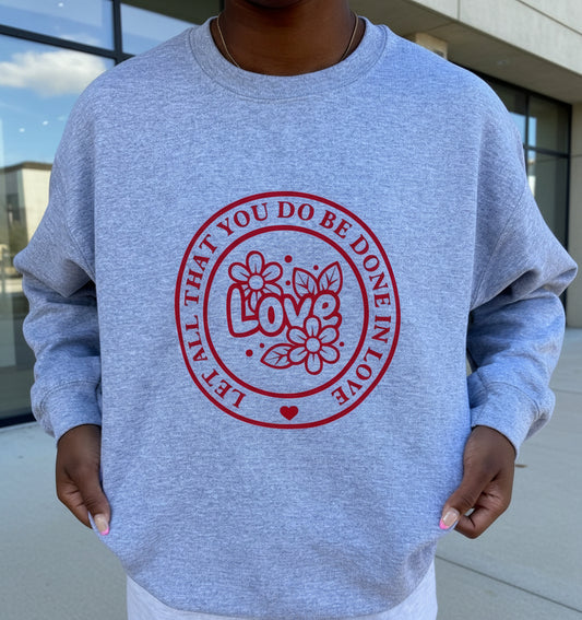 Gray sweatshirt with "Let All That You Do Be Done In Love" saying in a red circle.  The word "Love" and flowers in the center of the circle, Roxzell