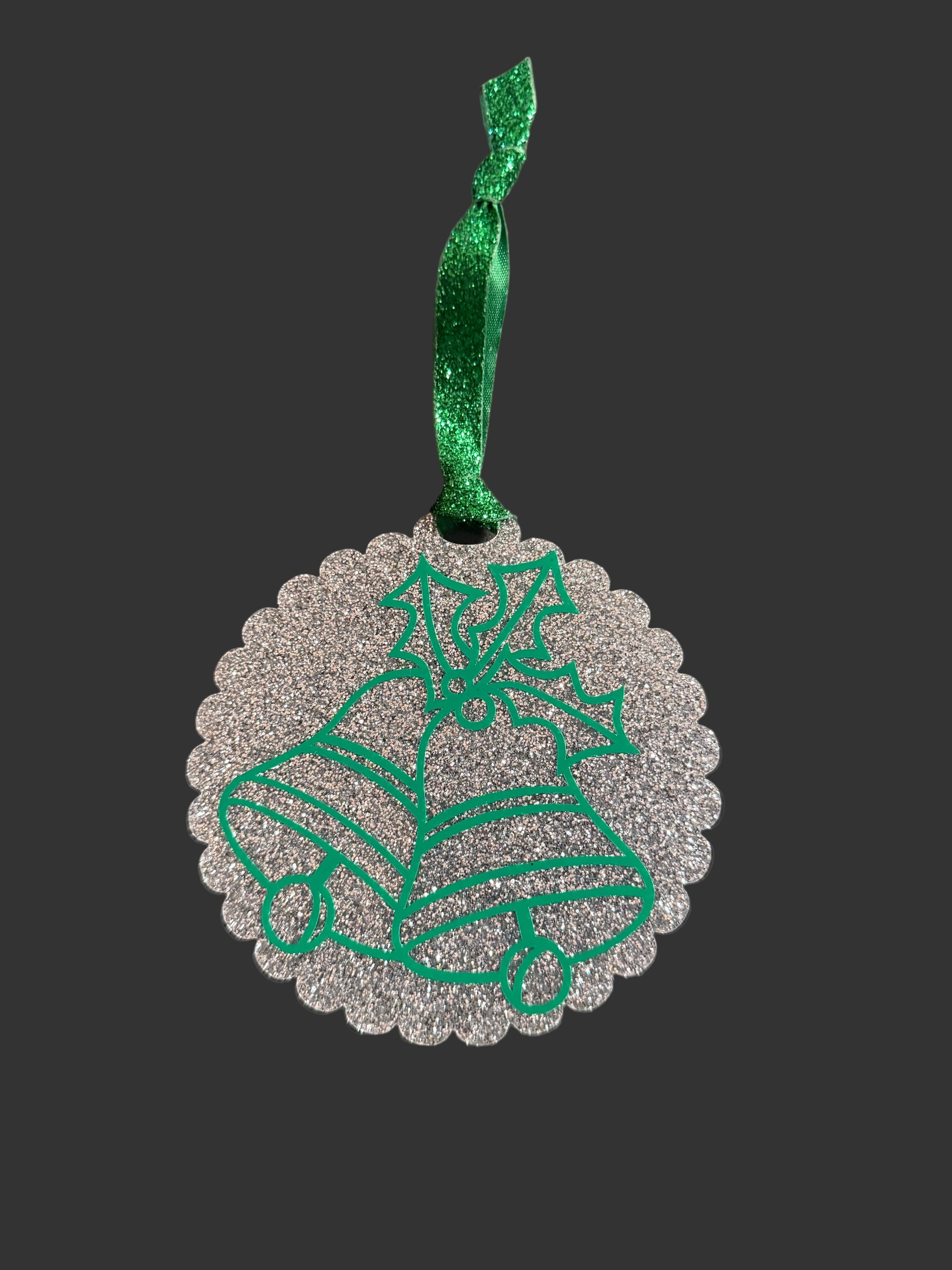 Christmas ornament with green glitter ribbon and silver base, showcasing bells and holly design. Roxzell