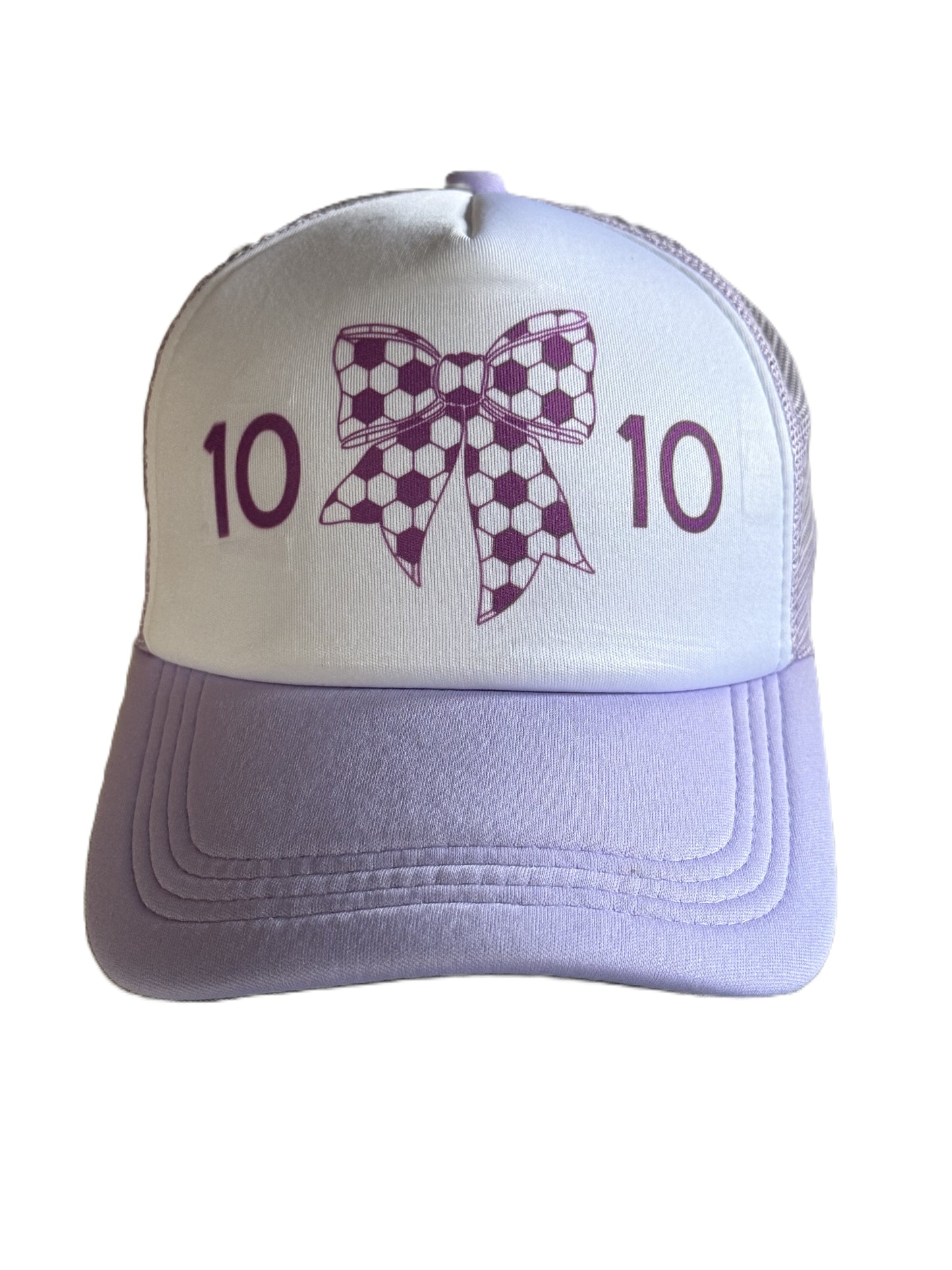 A lavender and white trucker hat featuring a purple soccer-ball-patterned bow graphic and the number '10' printed on each side of the bow, shown against a plain white background.