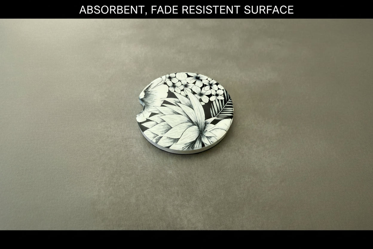 Decorative car coaster featuring detailed black and white botanical illustration on a gray surface with black border. Top border has "ABSORBENT, FADE RESISTENT SURFACE" text. Roxzell