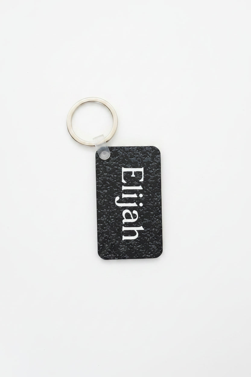 Personalized black speckle keychain with name Elijah in white.  Roxzell