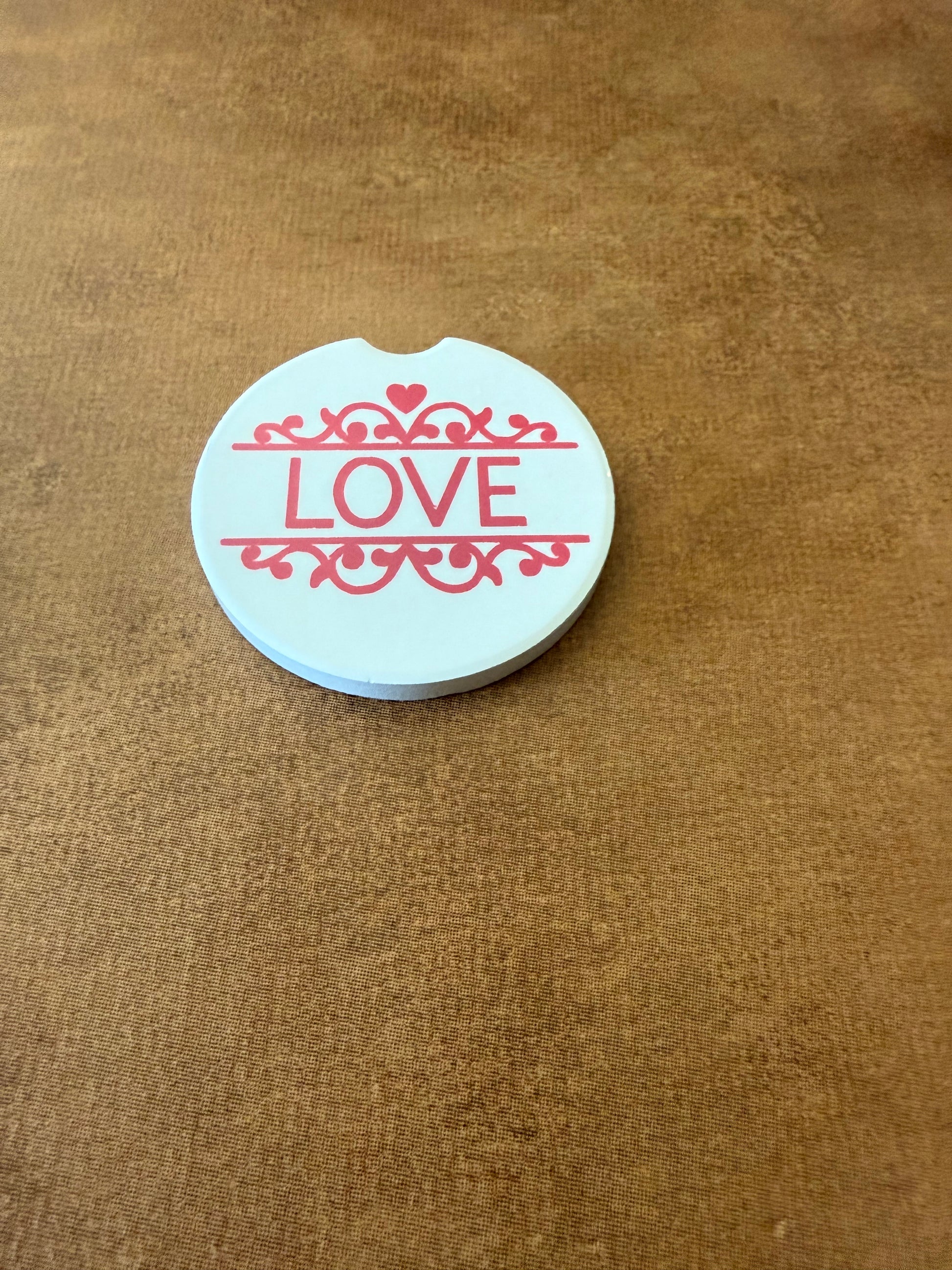 Decorative white car coaster with bold red “LOVE” lettering on a brown background, Roxzell