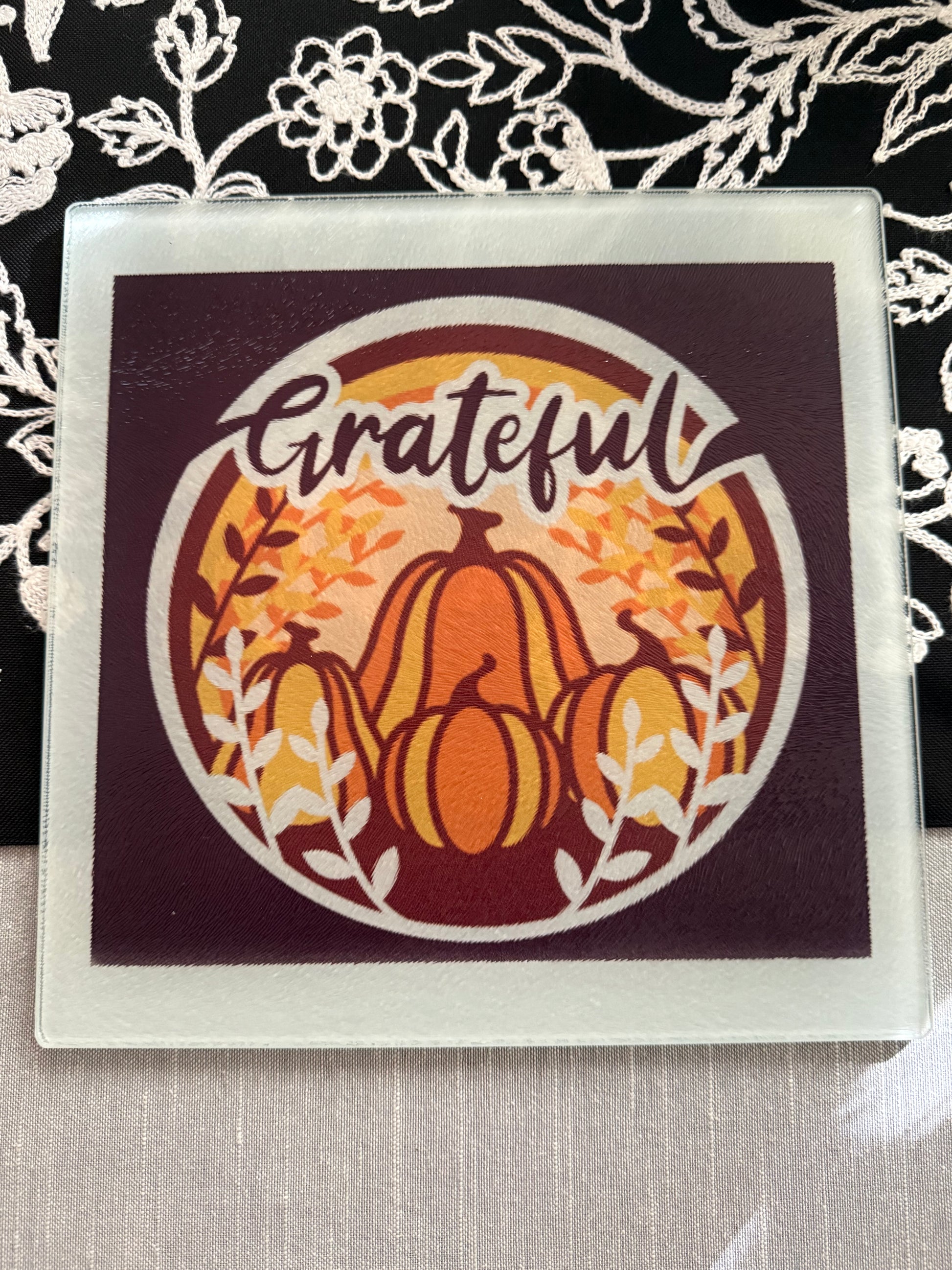 Close-up of maroon glass board with autumn design and white branches