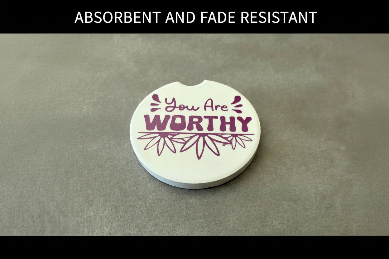 Decorative coaster with empowering message on a gray background with black border and words "ABSORBENT AND FADE RESISTANT" on the top border, Roxzell